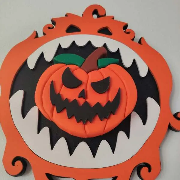 Gros plan sur une citrouille Halloween orange en relief entourée d’une bouche de monstre